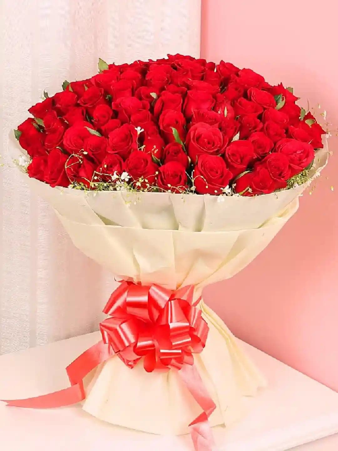 Red rose bouquet in cream wrapping with a red ribbon