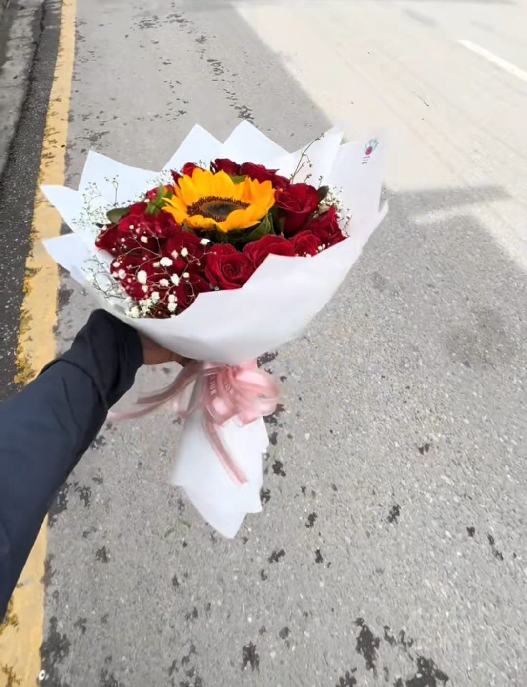 Sunflower and red rose bouquet in white wrapping